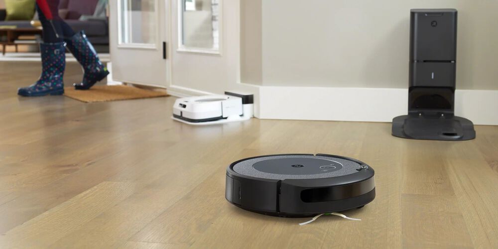 Un Roomba noir et un Roomba blanc en arri&egrave;re-plan